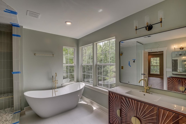 bathroom featuring tile patterned flooring, separate shower and tub, and vanity