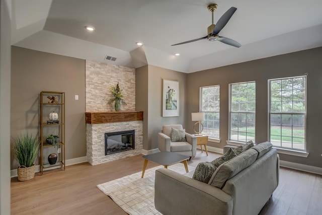 living room featuring a fireplace, vaulted ceiling, ceiling fan, and light hardwood / wood-style floors