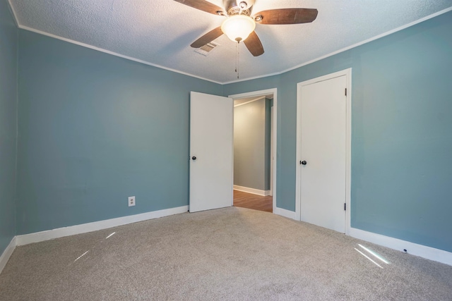 carpeted spare room with ornamental molding, a textured ceiling, and ceiling fan