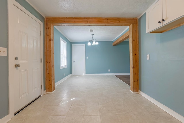 unfurnished dining area featuring a textured ceiling, a notable chandelier, and light tile patterned floors