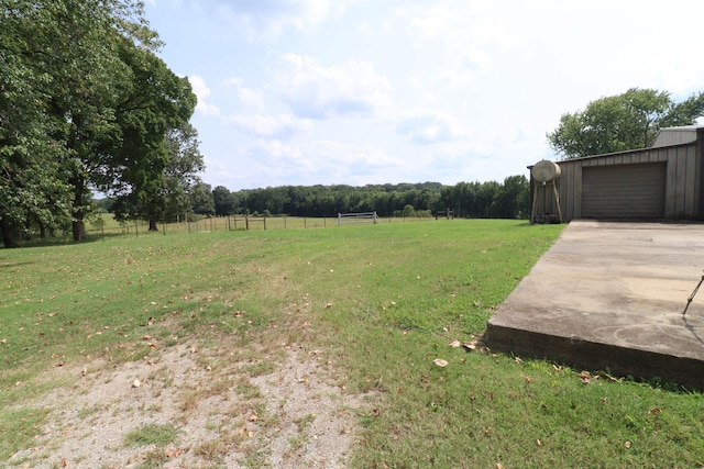 view of yard with a rural view and a garage