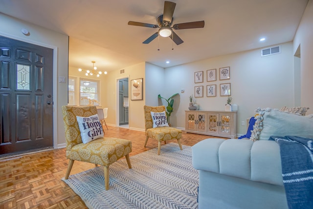 living room with ceiling fan with notable chandelier and parquet floors