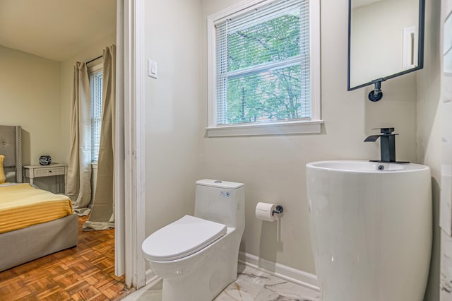 bathroom with parquet floors, toilet, and a wealth of natural light