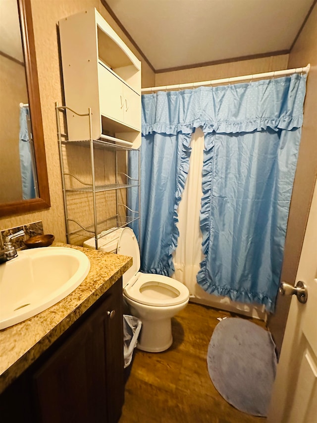 full bathroom featuring toilet, crown molding, vanity, wood-type flooring, and shower / tub combo