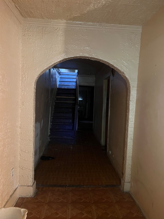 corridor featuring a textured ceiling and dark parquet flooring