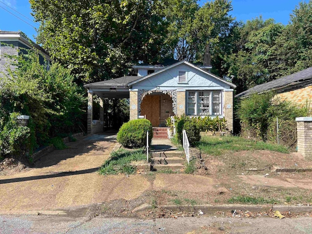 bungalow-style home with a porch and a carport