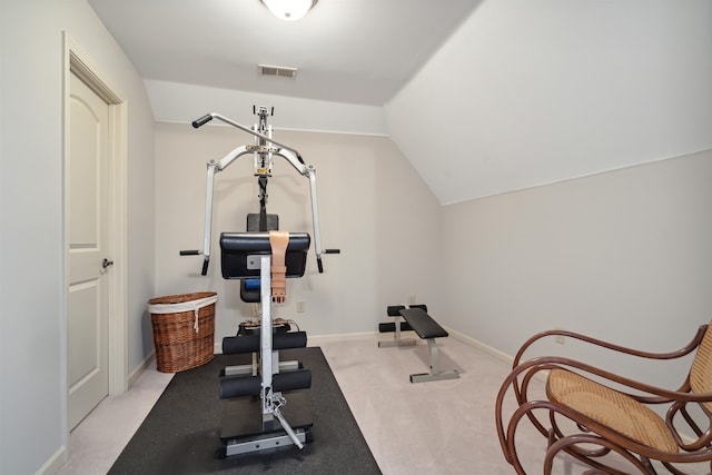 exercise room with lofted ceiling and light colored carpet