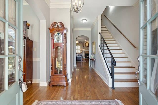 entryway featuring crown molding, plenty of natural light, hardwood / wood-style floors, and an inviting chandelier