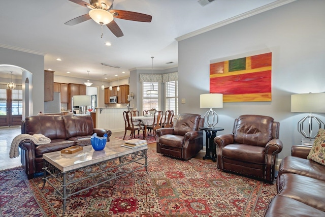 living room featuring ornamental molding and ceiling fan with notable chandelier