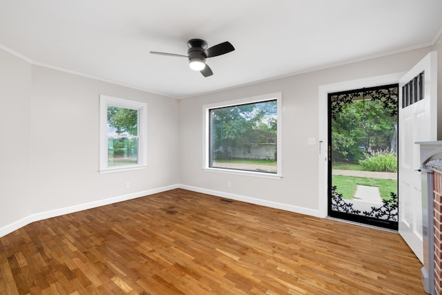 spare room with hardwood / wood-style floors, ceiling fan, and a fireplace