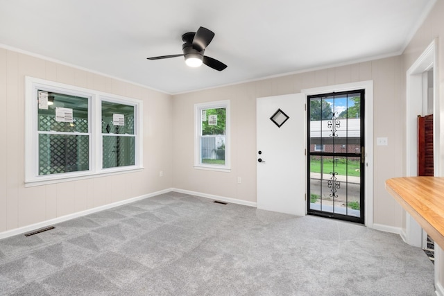 interior space featuring ceiling fan, ornamental molding, and a healthy amount of sunlight