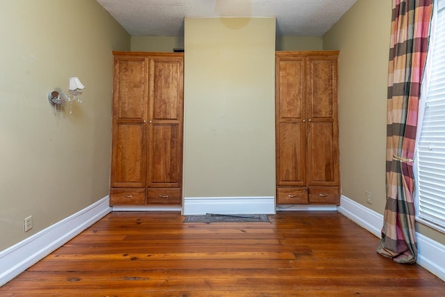 interior space featuring dark wood-type flooring and a textured ceiling