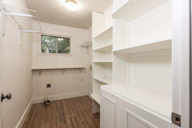 washroom featuring dark wood-type flooring, electric dryer hookup, and a textured ceiling