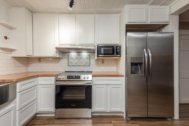 kitchen featuring dark wood-type flooring, butcher block counters, stainless steel appliances, and white cabinets