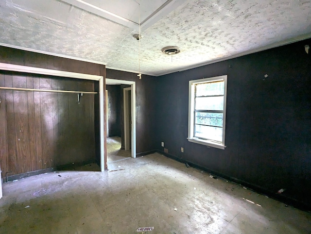 unfurnished bedroom featuring wooden walls