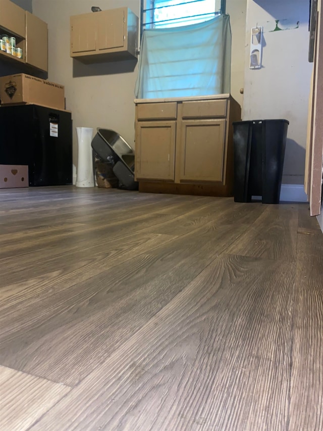kitchen featuring wood finished floors, light countertops, and refrigerator