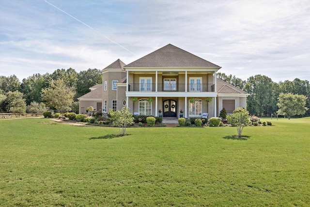 view of front of property with french doors, roof with shingles, a front lawn, a porch, and a balcony