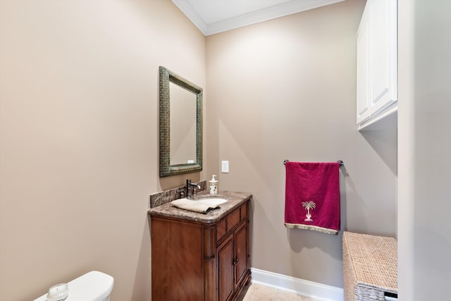 bathroom featuring vanity, toilet, and ornamental molding