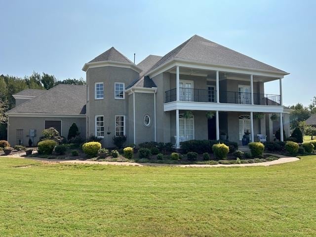 view of front of home featuring a balcony and a front lawn