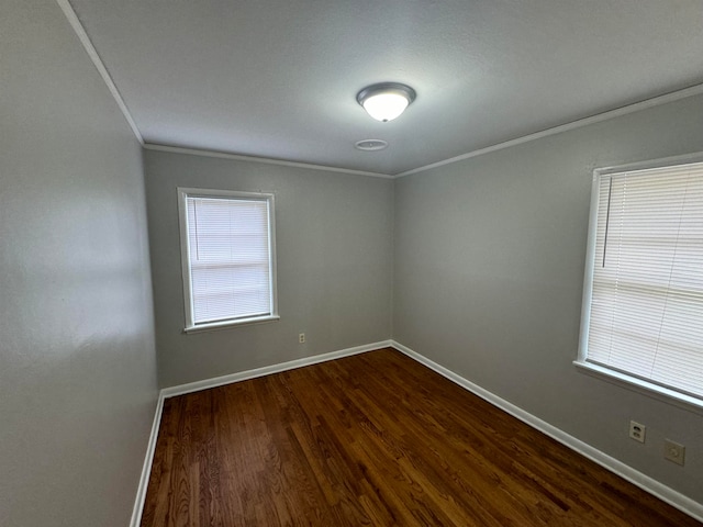 empty room with ornamental molding and dark hardwood / wood-style floors