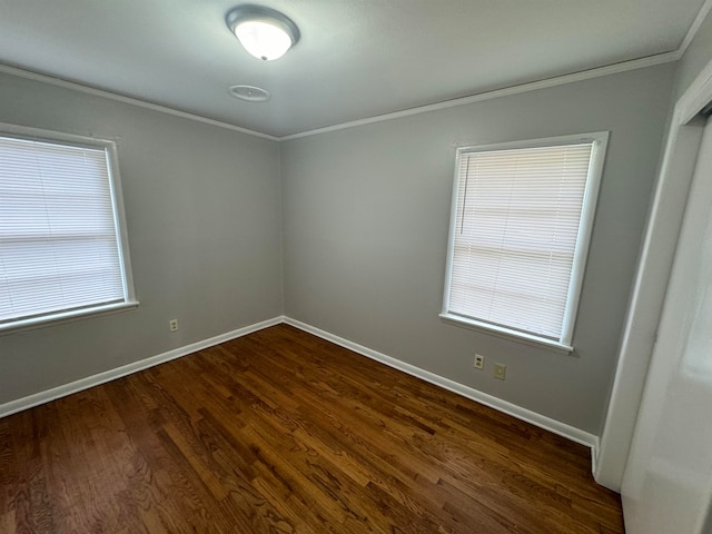 spare room featuring crown molding and dark hardwood / wood-style flooring