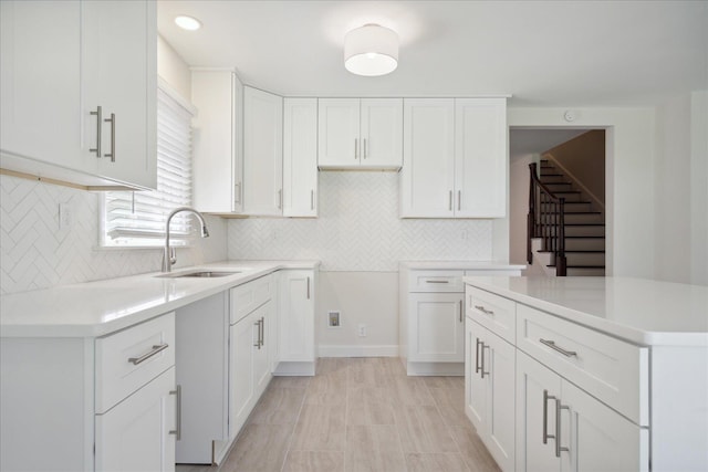 kitchen featuring sink, white cabinets, and tasteful backsplash