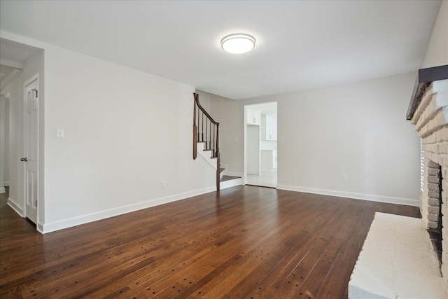 unfurnished living room featuring a fireplace and dark hardwood / wood-style floors