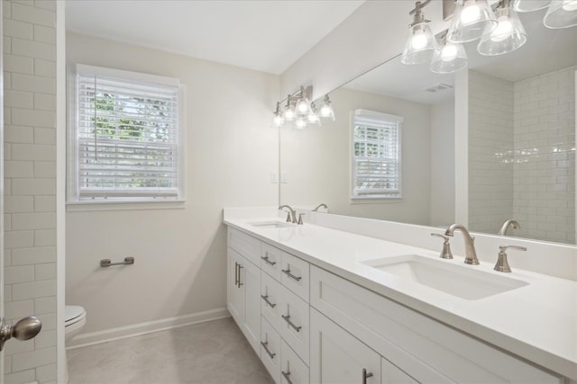 bathroom featuring toilet, a notable chandelier, and vanity