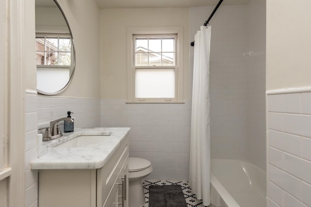 full bathroom with tile patterned flooring, shower / bath combo, toilet, tile walls, and vanity