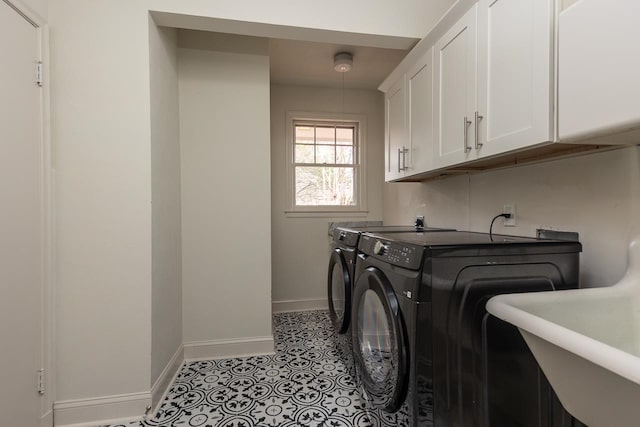 clothes washing area featuring cabinets, washing machine and dryer, and sink