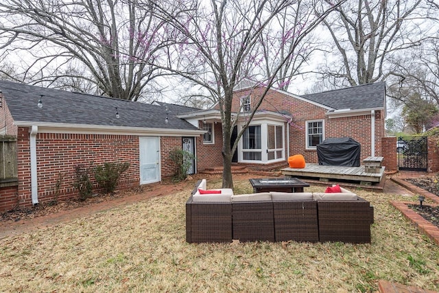 back of house featuring a wooden deck and a lawn