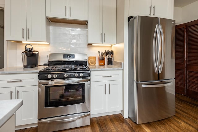 kitchen with appliances with stainless steel finishes, tasteful backsplash, dark hardwood / wood-style floors, and white cabinetry