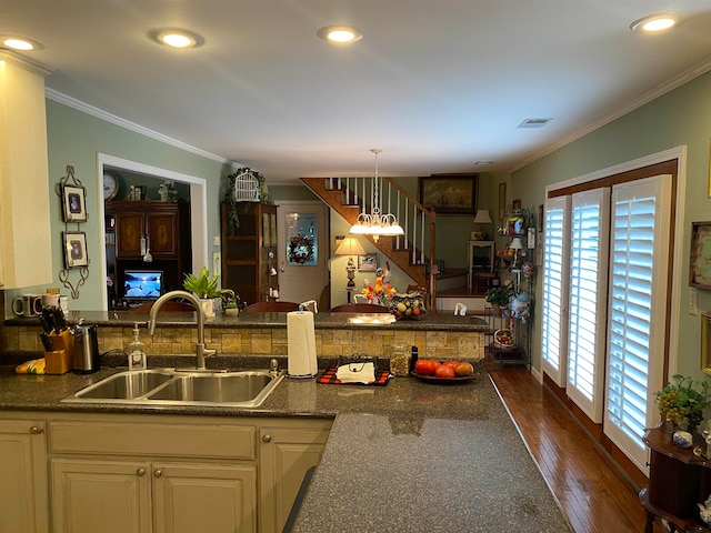 kitchen featuring ornamental molding, decorative light fixtures, kitchen peninsula, sink, and dark wood-type flooring