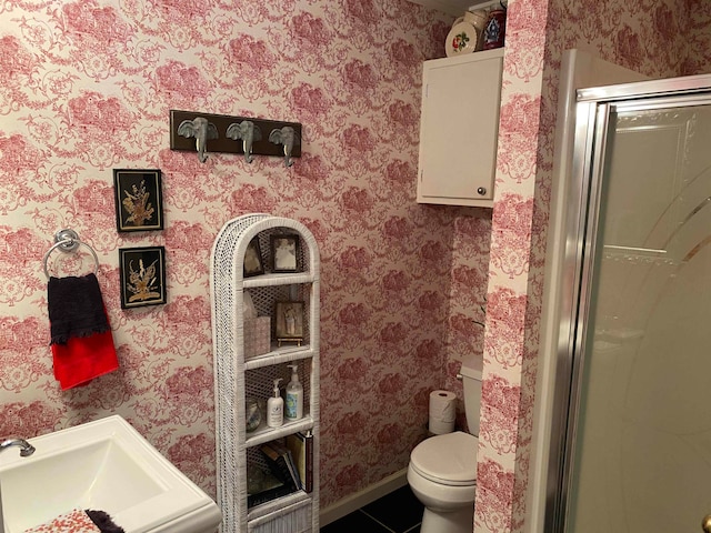 bathroom featuring tile patterned flooring, a shower with shower door, and toilet