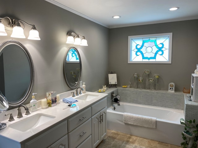 bathroom featuring plenty of natural light, a bathing tub, ornamental molding, and vanity