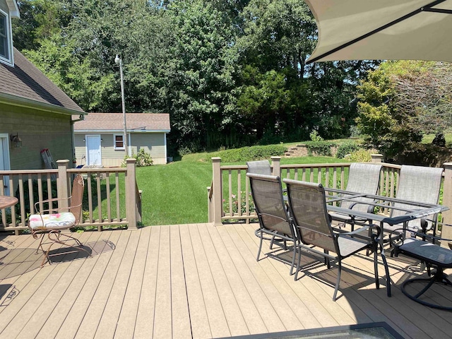 wooden deck with a storage unit and a yard