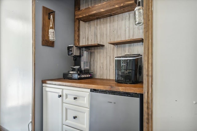 bar with pendant lighting, stainless steel refrigerator, butcher block countertops, and white cabinetry