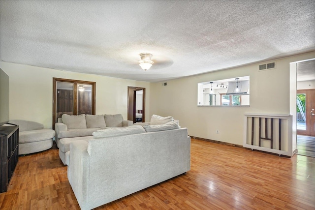 living room featuring light wood-type flooring and a healthy amount of sunlight