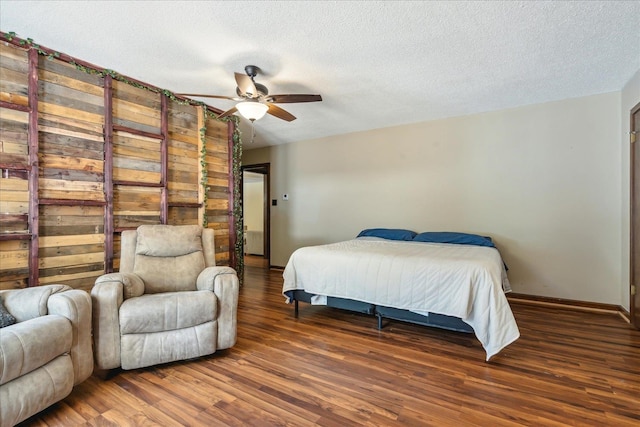 bedroom featuring a textured ceiling, ceiling fan, and dark hardwood / wood-style floors