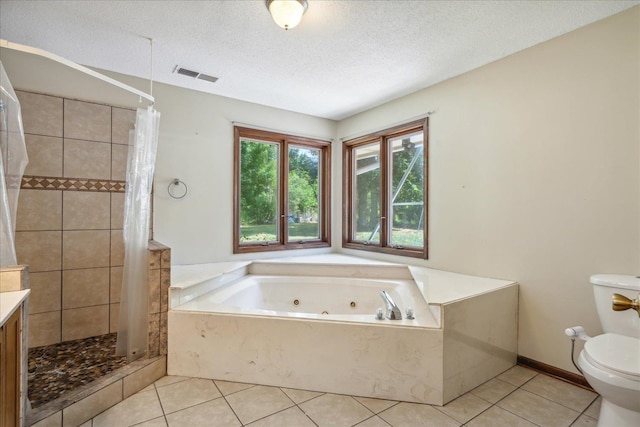 full bathroom featuring toilet, plus walk in shower, tile patterned flooring, vanity, and a textured ceiling