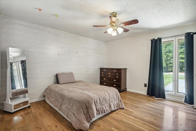 bedroom featuring a textured ceiling, ceiling fan, and light hardwood / wood-style floors