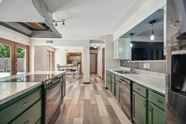 kitchen featuring light hardwood / wood-style flooring, stainless steel appliances, sink, and green cabinetry