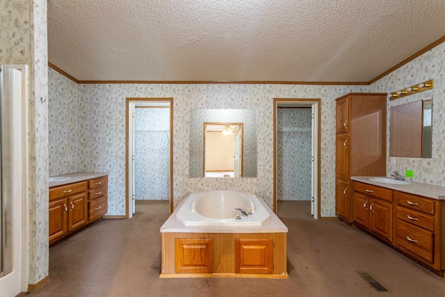 bathroom with vanity, a washtub, ornamental molding, and a textured ceiling