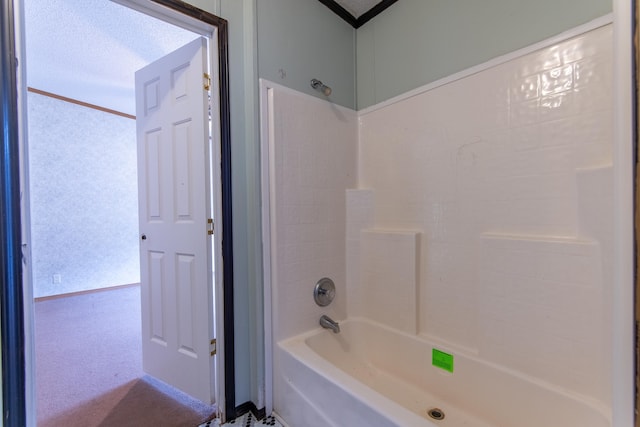 bathroom with a textured ceiling and bathtub / shower combination