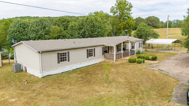 back of house with central AC unit, a yard, and a carport