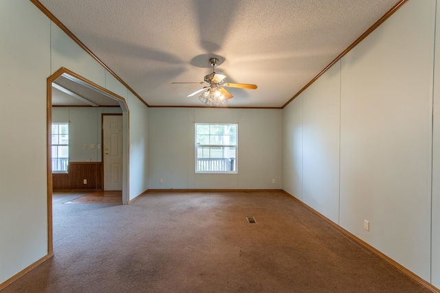 empty room with a textured ceiling, plenty of natural light, and ceiling fan