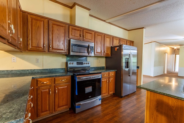 kitchen featuring crown molding, dark hardwood / wood-style flooring, stainless steel appliances, and a textured ceiling