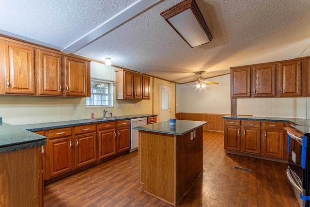 kitchen featuring ceiling fan, a center island, dark hardwood / wood-style flooring, and a textured ceiling