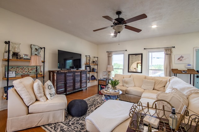 living room with a textured ceiling, ceiling fan, and hardwood / wood-style floors