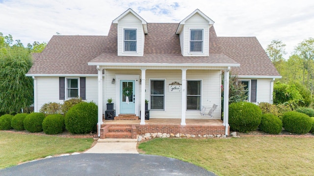 cape cod home with a porch and a front yard